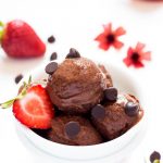 Chocolate Banana Ice Cream Scoops in a bowl with chocolate chips and strawberry