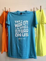 Orange, blue, and green t-shirts with SSDP artwork on them