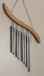 Photo of a set of wind chimes hanging against the wall.
