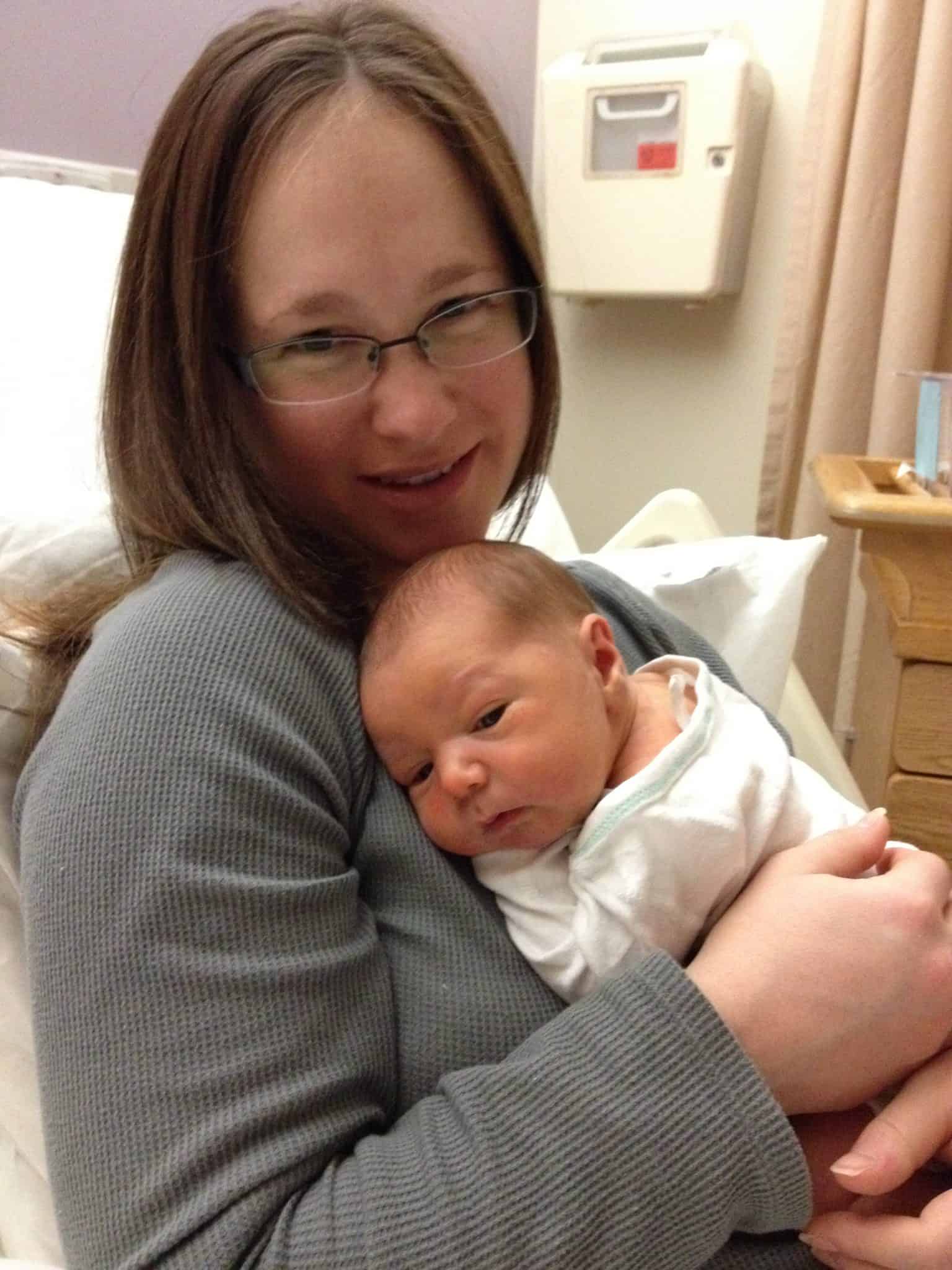 Woman in hospital bed, holding newborn baby - swollen from preeclampsia