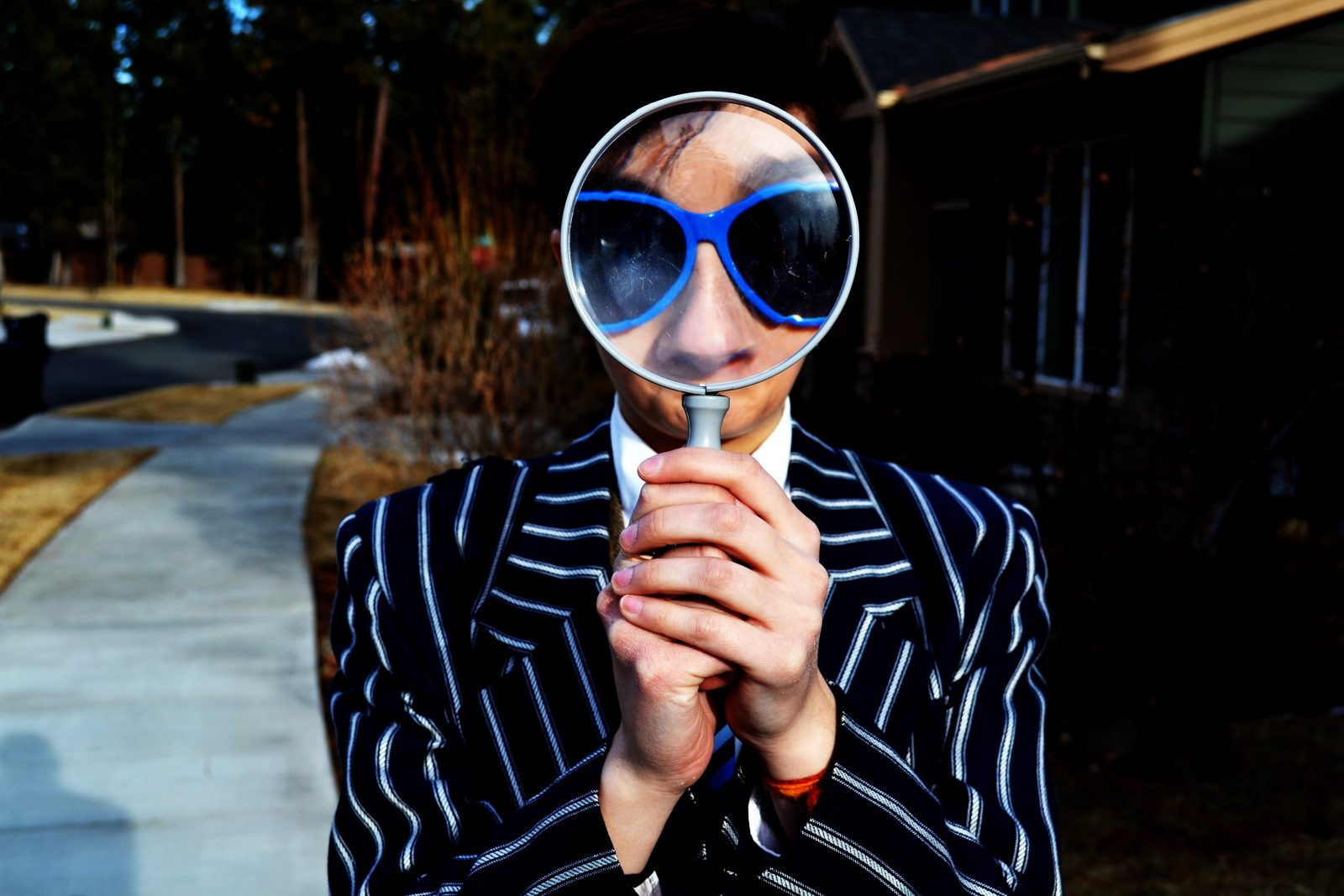 Low Vision Mann mit blauer Brille und großer Lupe