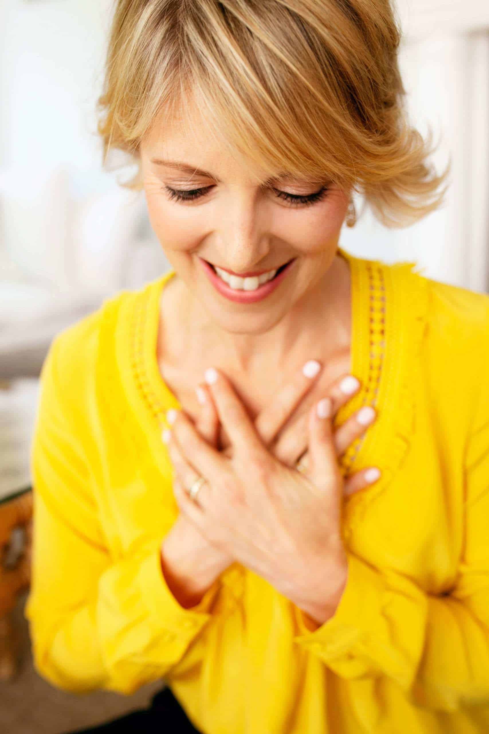 Elizabeth Hunter Diamond, clairvoyant energy healer, in yellow shirt with hands on heart, teaching manifesting love.