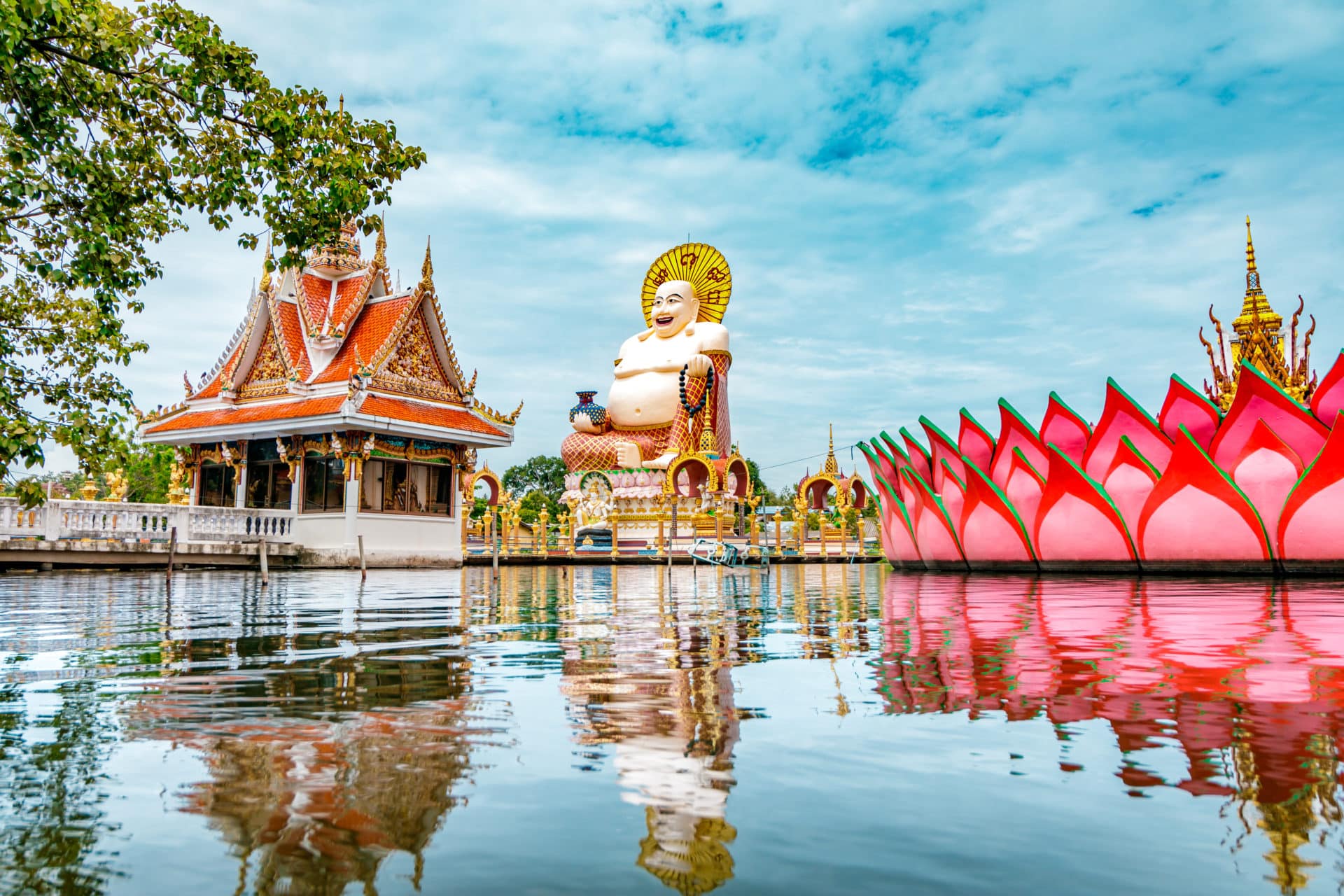 Wat Plai Laem Buddhism Temple statues during a bright sunny day with lake in the foreground in Koh Samui, Surat Thani, Thailand