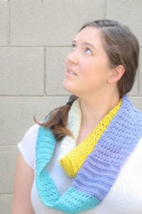 Want a quick and easy friday night project? Work up this free crochet pattern for an infinity scarf with lots of unique texture and appeal. This is a one skein project that you can have ready for the weekend. My example uses Caron Cakes yarn and is a bright and colorful addition to my wardrobe.