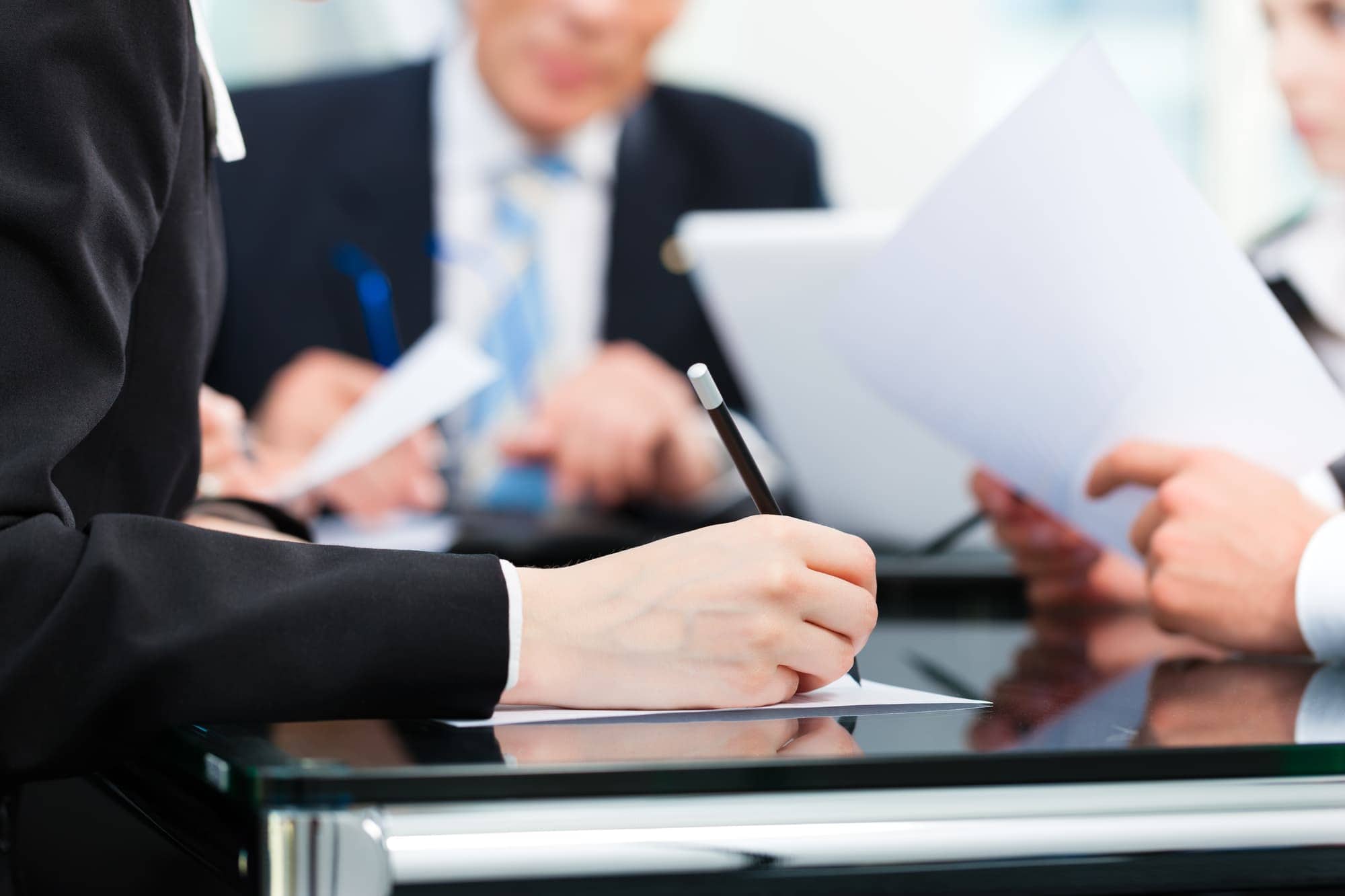 attorney meeting Attorney and Clients holding papers and meeting around a table to discuss bankruptcy exemptions