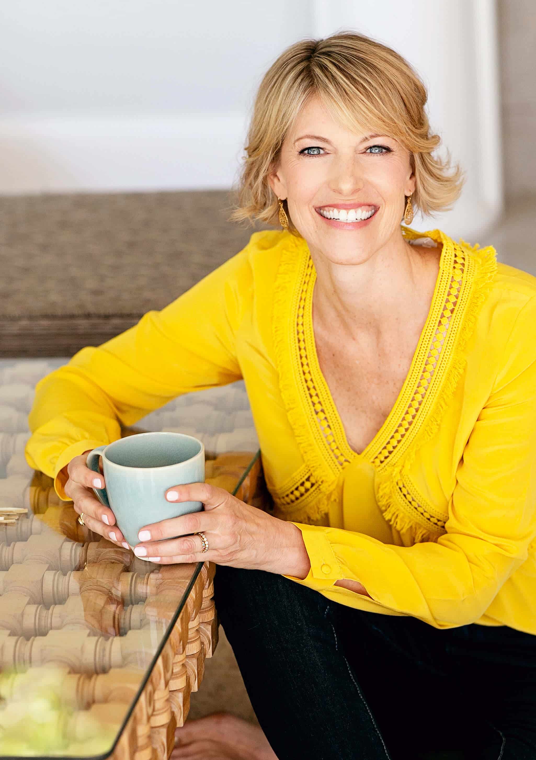 Elizabeth Hunter Diamond gives clairvoyant reading & energy healing, in yellow blouse holding blue coffee cup..