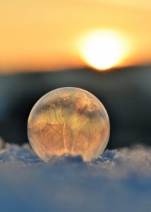 frost-etched orb on frozen blue surface in winter sunlight