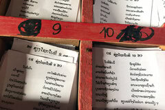 Fortune sticks, poetry and boxes of paper notes in Lao Buddhist temples