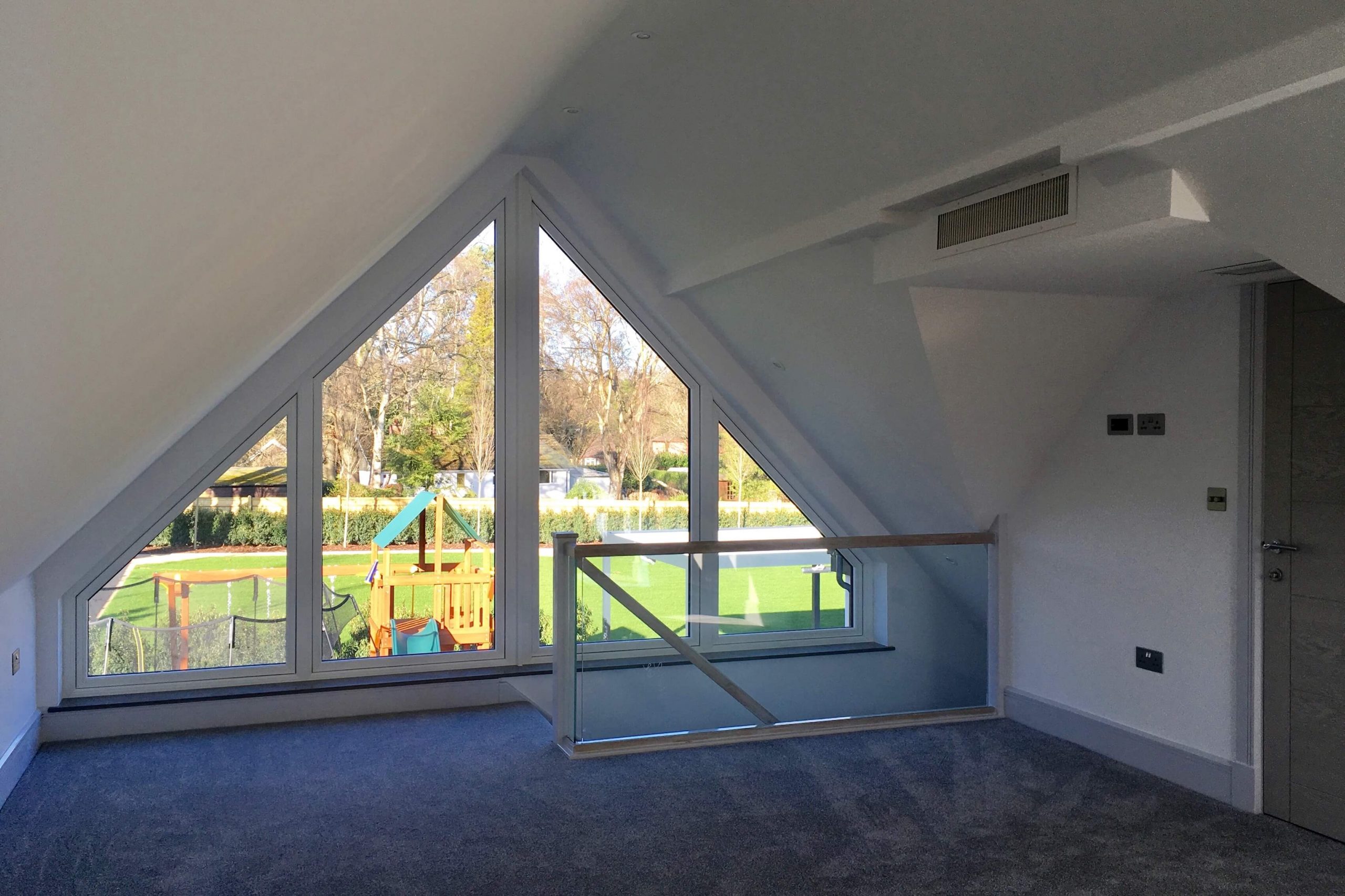 Scandia Hus new build project upstairs bedroom overlooking garden with 2 air grills by door as part of MVHR and air conditioning system by SubCool FM