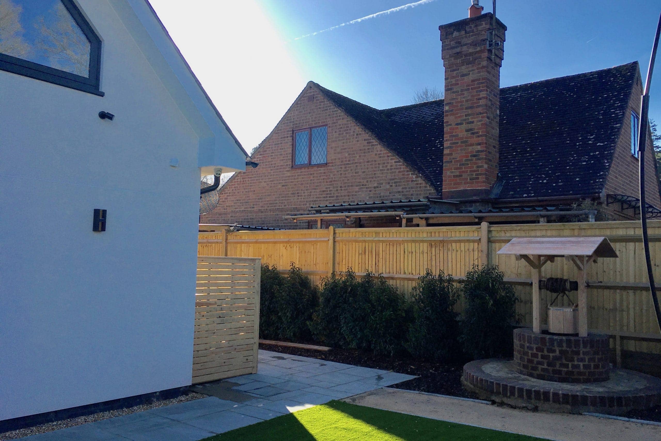 Outdoor MVHR & aircon units in discreet wooden area at domestic build side view