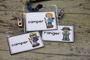 Photo of 3 name badges for students playing in a dramatic play center. These badges have roles for campers and ranger in a camping themed center.