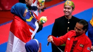 President Jokowi handled over the gold medal to Defia Rosmaniar, taekwondo athlete who won Indonesias first gold in 2018 Asian Games. (Photo: IST)