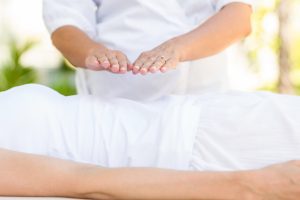 Example of a Reiki healing, the practitioners hands suspended above the patient.