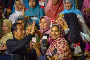 President Jokowi takes a group photo with Family Hope Program recipients at East Jakarta Sports Hall, Jakarta, Monday (3/12). (Photo: AGUNG/PR)