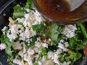 Adding the dressing to the salad and tossing it well before serving
