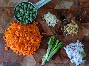 Ingredients chopped for the sweet corn soup - carrots, peas, scallions, ginger and garlic