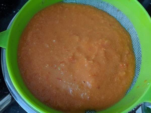 straining the tomato puree for the soup