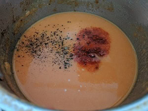 Soup simmering with salt, black pepper and kashmiri red chilli powder