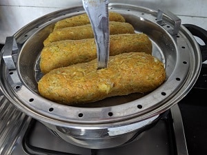 Checking to see if the muthiya has steamed by inserting a knife
