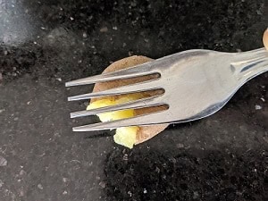 smashing the potatoes using a fork