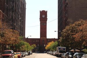 Chicago's historic Dearborn Station, a red brick clock tower faces North on Dearborn Street. Flanked by Printers Row historic buildings.