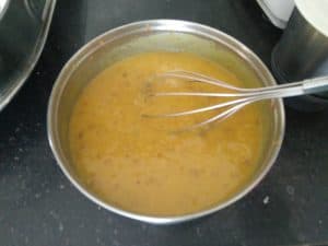 Whisk the tur dal for smooth texture of Ambat Goad Varan