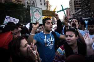 An Egyptian protestor holds the Koran and a cross as hundreds of Egyptians from different political opposition parties and different religions march towards St. Mark's Coptic Orthodox Cathedral in Abbasya to denounce sectarian violence and the Egyptian government on April 9, 2013 in Cairo. Egypt's Pope Tawadros II accused President Mohamed Morsi of "negligence" in his response to deadly clashes outside Cairo's Coptic cathedral, the worst sectarian crisis since he took power in June. (Gianluigi Guercia/AFP/Getty Images)