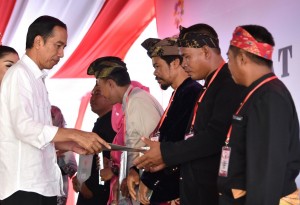President Jokowi hands in land certificates to representatives of the people at at the field of Nurul Bilad Mosque in Mandalika Special Economic Zone (KEK) in Lombok Tengah Regency, West Nusa Tenggara province, Friday (20/10). (Photo by: Rahmad/Public Relations Division)