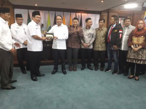 Ketua Komisi DPR RI Zainudin Amali menerima cendera mata dari Sekda NTB Rosiady Sayuti dalam pertemuan di Gedung Pemrov NTB, Mataram, Rabu (28/2) siang. (Foto: Edi N/Humas)