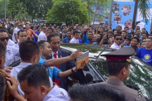 President Jokowi taking a picture with a student after giving scientific oration at 65th Dies Natalis UKI, in Cawang, Jakarta, Monday (15/10). (Photo: JAY/PR)