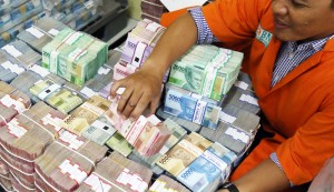 Uang Tunai BNI Petugas mengatur tumpukan uang di cash center BNI, Kamis (29/12). Uang tunai yang disiapkan BNI untuk memenuhi kebutuhan selama masa liburan Natal 2016 dan Tahun Baru 2017 mencapai sekitar Rp 11 triliun. Investor Daily/David Gita Roza