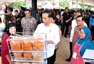 Presiden Jokowi didampingi sejumlah pejabat meninjau salah satu stand peserta program Mekaar, di Lapangan Asrama Polisi Kelurahan Gunung Sahari Selatan, Kecamatan Kemayoran, Jakarta Pusat (Jakpus), Sabtu (26/1) siang. (Foto: JAY/Humas)