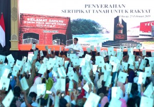 Recipients of land certificates raise their certificates up in the air before President Jokowi, at the distribution of land certificates, in Cilacap, Central Java, Monday (25/2). (Photo by: Rahmat/ PR Division)