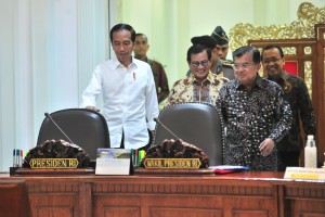: President Jokowi, accompanied by Vice President, Minister of State Secretary, and Cabinet Secretary, enters the Presidential office before a Limited Cabinet Meeting on Tuesday (19/3). (Photo by: Jay/PR)