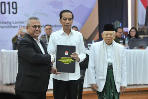 Ketua KPU Arief Budiman menyerahkan salinan Keputusan KPU tentang Penetapan Paslon Presiden dan Wapres Terpilih Pemilu 2019 kepada Paslon Terpilih Jokowi dan Ma'ruf Amin, di Kantor KPU, Jakarta, Minggu (30/6) sore. (Foto: Humas/Jay)