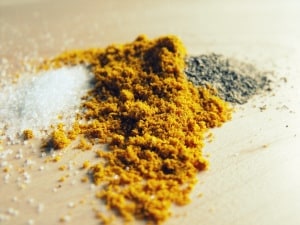 salt, pepper and curry on a wood board