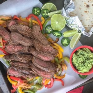 The Best and Easiest Garlic Lime Steak Fajitas - these steak fajitas are easier to make than you think and absolutely delicious! Tender marinated flat iron steak served with sautéed bell peppers, onions, and a creamy Cilantro Lime Avocado Mash. #steak #dinner #easy #steakfajitas #fajitas #mexican #onepan | www.withpeanutbutterontop.com