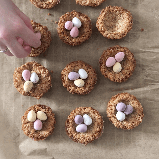 Flapjack Easter Nests being studded with mini eggs.
