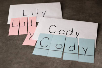 Photo of student names cut into puzzles (one letter per piece.) Original names are written on an envelope for reference.
