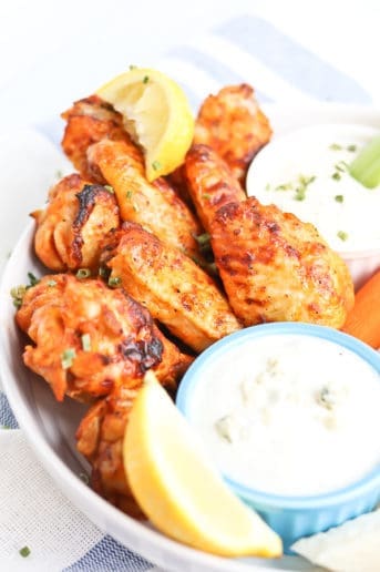 chicken wings on a plate with carrots and celery