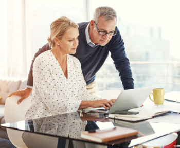 Mature couple reviewing finances on laptop