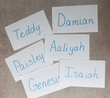 Photo of 6 student name cards spread out on a table.