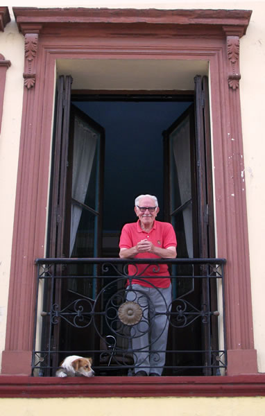 WA-santelmo-victorio A resident and senior citizen in San Telmo, Buenos Aires admiring the view from his French balcony.