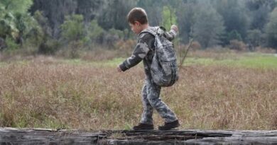 Kids’ Bug Out Bag | Gear List with Pro Tips Kid Hiking on Log with Backpack