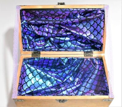 lace holding up mermaid party centerpiece treasure chest lid