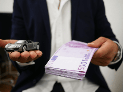 Auto ja rahatukku kädessä
