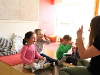 Pädagogin spielt mit kleinen Kindern Fingerspiele