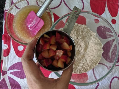 Dry and wet ingredients laid out separately with chopped plums