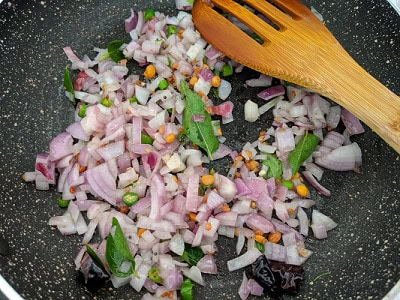 Add chopped onions and curry leaves to the tempering