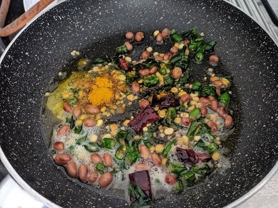 adding turmeric powder and asafoetida to the tempering